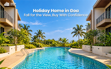Holiday home in Goa featuring a luxurious swimming pool, tropical palm trees, and modern villas under a clear blue sky.